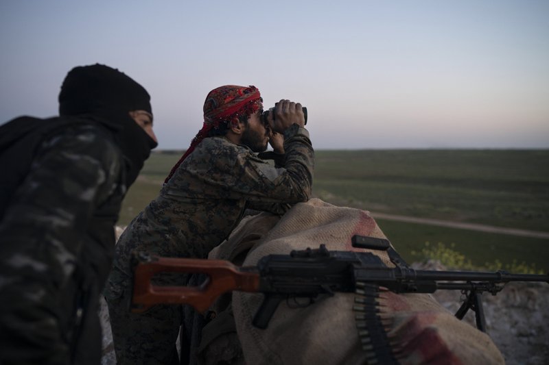 FILE - In this Tuesday, Feb. 19, 2019 file photo, U.S.-backed Syrian Democratic Forces fighters watch as an airstrike hits territory still held by Islamic State militants in the desert outside Baghouz, Syria. U.S. and Iraqi officials say IS fighters facing defeat in Syria are slipping across the border into Iraq, where they are destabilizing the country&#x2019;s fragile security. Hundreds -- likely more than 1,000 -- IS fighters have crossed the open, desert border in the past six months, defying a massive operation by U.S., Kurdish, and allied forces to stamp out the remnants of the jihadi group in eastern Syria. (AP Photo/Felipe Dana, File)