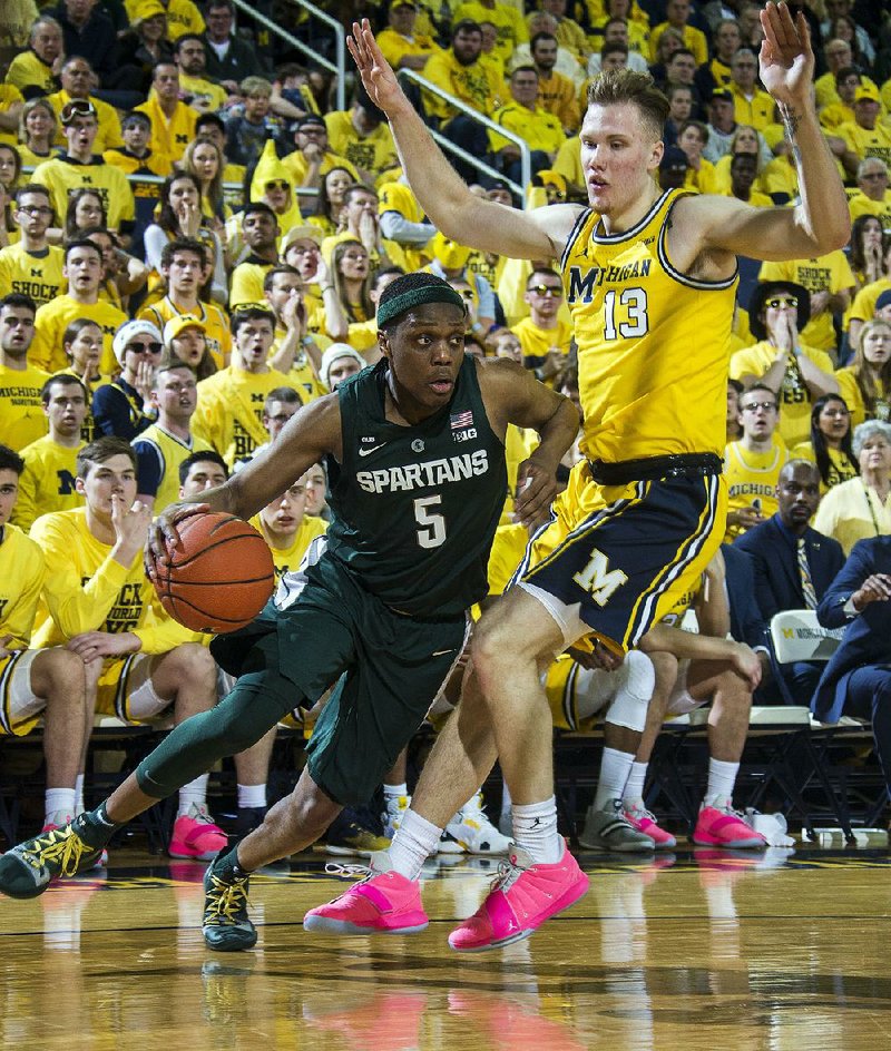 Michigan State guard Cassius Winston (5) drives against Michigan forward Ignas Brazdeikis (13) in the first half Sunday at Crisler Center in Ann Arbor, Mich. Winston had 27 points and eight assists as Michigan State won 77-70.