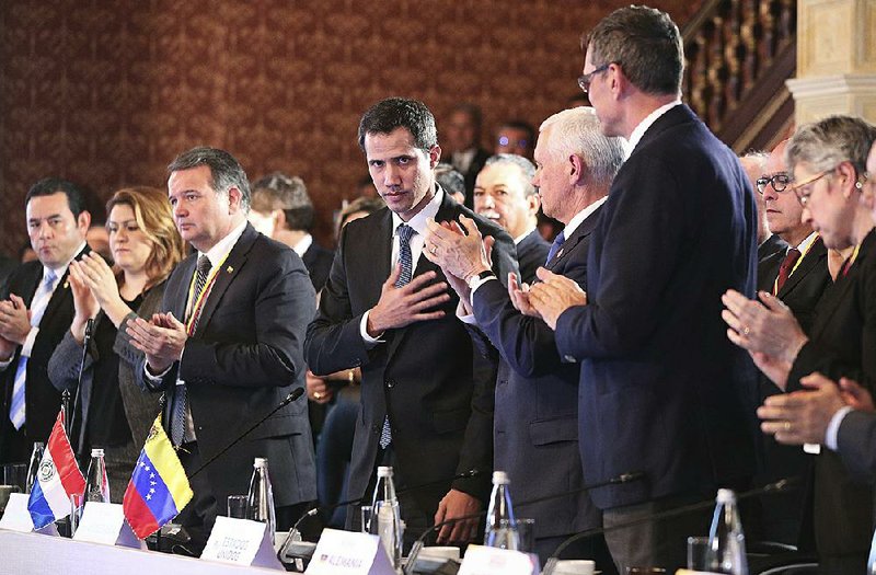Flanked by Vice President Mike Pence (right center), Venezuela’s self-proclaimed interim president Juan Guaido acknowledges the applause during a meeting of the Lima Group concerning Venezuela at the Foreign Ministry in Bogota, Colombia, on Monday.