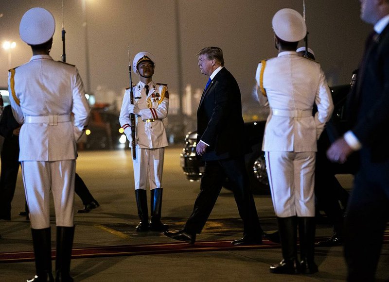 A Vietnamese honor guard greets President Donald Trump as he arrives Tuesday evening in Hanoi after a more than 20-hour flight aboard Air Force One. 