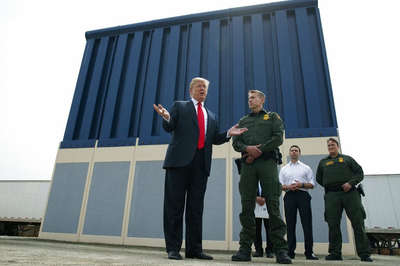 FILE - In this March 13, 2018, file photo, President Donald Trump talks with reporters as he reviews border wall prototypes in San Diego. The Trump administration on Wednesday, Feb. 27, 2019, began demolishing eight prototypes of the president's prized border wall, saying they have served their purpose. (AP Photo/Evan Vucci, File)