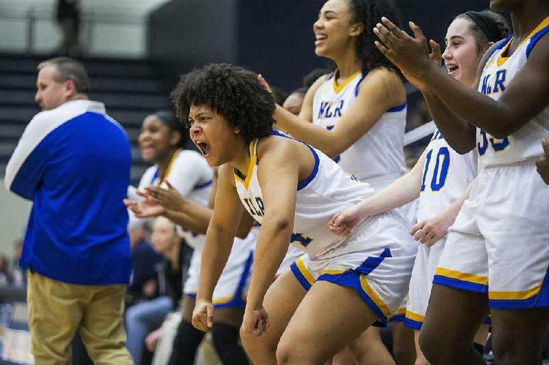 Zoe Adebyo (center) and other North Little Rock players celebrate during the Lady Charging Wildcats’ 69-40 victory Wednesday over host Bentonville West at the Class 6A girls basketball state tournament at Centerton 