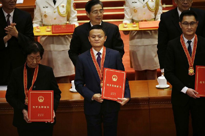 Jack Ma (center), billionaire chairman of Chinese e-commerce firm Alibaba Group, attends a December conference in Beijing. Ma is the world’s 22nd-most-wealthy person. 