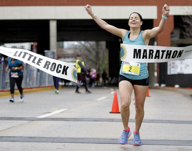 Tia Stone of Little Rock celebrates as she crosses the finish line to win the 2018 Little Rock Marathon. (Arkansas Democrat-Gazette/THOMAS METTHE)

