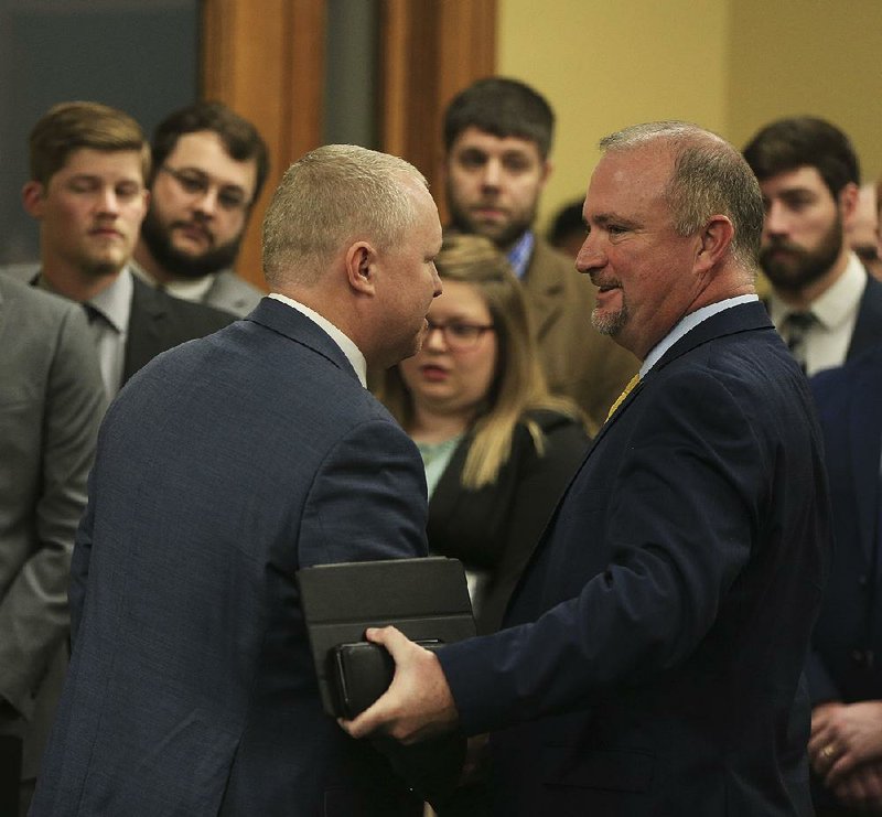 Rep. Les Eaves, R-Searcy, shakes hands Thursday with John Vin- son (left), chief operating officer of the Arkansas Pharmacists Association, at the state Capitol after Eaves’ bill to allow pharmacists to dispense tobacco cessation products passed out of the House Public Health, Welfare and Labor Committee. More photos are online at arkansasonline.com/301genassembly/. 