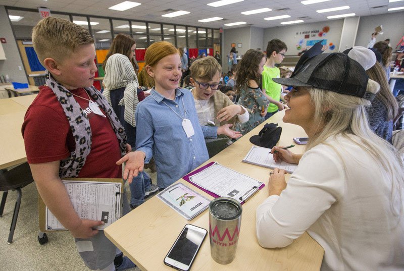 NWA Democrat-Gazette/BEN GOFF &#8226; @NWABENGOFF Hudson Roach (from left), Evan Craig and Paxton Bronner, all third-graders, portray Friday an immigrant family as Hudson's mother, Tara Roach, portrays an immigration officer during an Ellis Island simulation at Darr Elementary School in Rogers. The third-graders at the school have been learning about the history of immigration in their social studies classes over the past four weeks. The students, some in costume, learned in the simulation what immigrants experienced when they arrived at Ellis Island in New York in 1910.