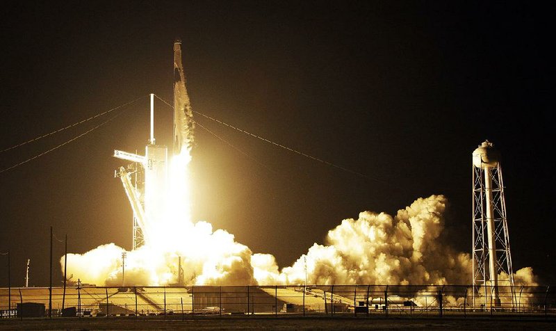 A rocket launches SpaceX’s unmanned Crew Dragon spacecraft from the Kennedy Space Center in Cape Canaveral, Fla., on Saturday in a test flight to the International Space Station. 