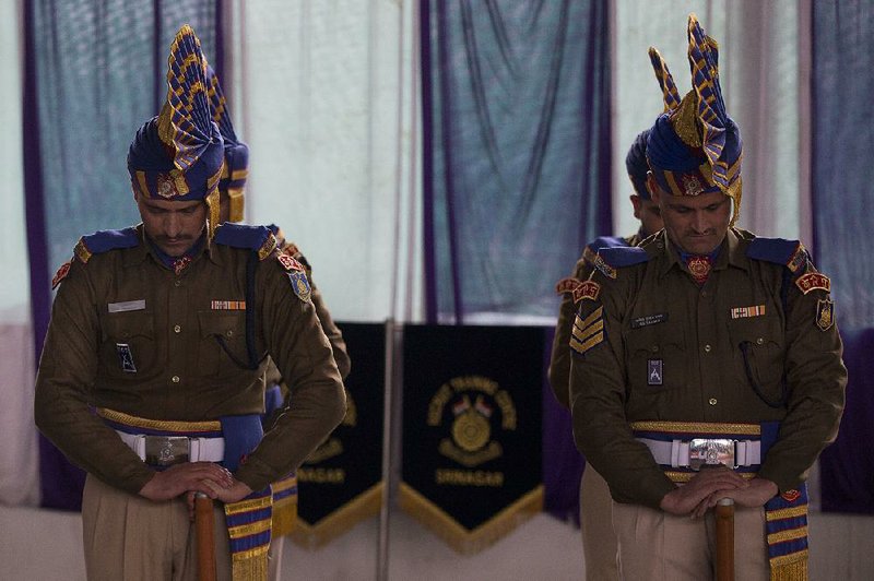 Indian paramilitary soldiers bow during a wreath-laying ceremony Saturday for fallen comrades at a base camp on the outskirts of Srinagar in Indian-controlled Kashmir. Several civilians and soldiers have been killed on both sides during renewed clashes between Indian and Pakistani forces. 