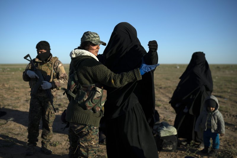 A woman is frisked by a U.S.-backed Syrian Democratic Forces (SDF) fighter at a screening area after being evacuated out of the last territory held by Islamic State militants, in the desert outside Baghouz, Syria, Friday, March 1, 2019. (AP Photo/Felipe Dana)