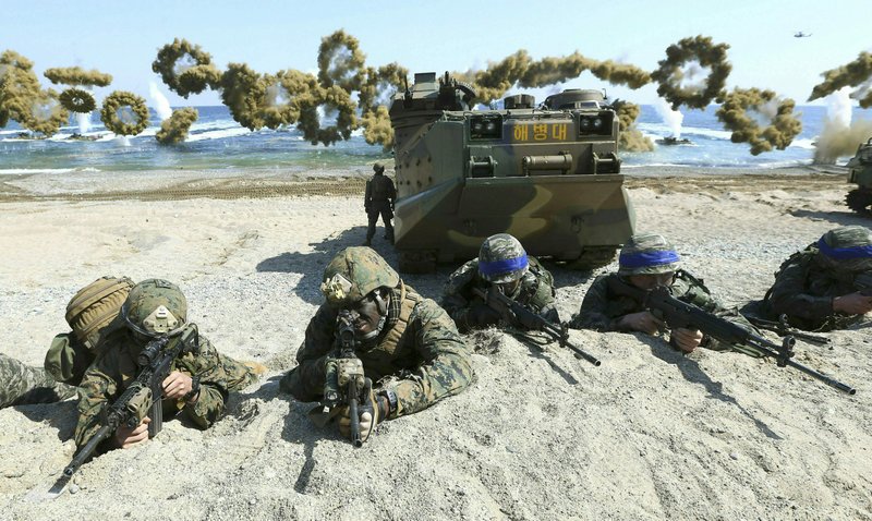 In this March 12, 2016, file photo, Marines of the U.S., left, and South Korea, wearing blue headbands on their helmets, take positions after landing on a beach during the joint military combined amphibious exercise, called Ssangyong, part of the Key Resolve and Foal Eagle military exercises, in Pohang, South Korea. South Korea and the U.S. say they've decided to end their springtime military drills to back diplomacy with North Korea. (Kim Jun-bum/Yonhap via AP, File)