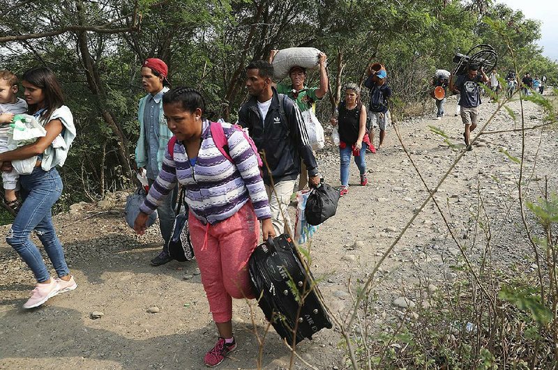 Venezuelans cross illegally into Colombia on Sunday near the Simon Bolivar International Bridge. Venezuelan authorities closed the crossing last week after a showdown over the opposition’s attempt to get humanitarian aid into the country.