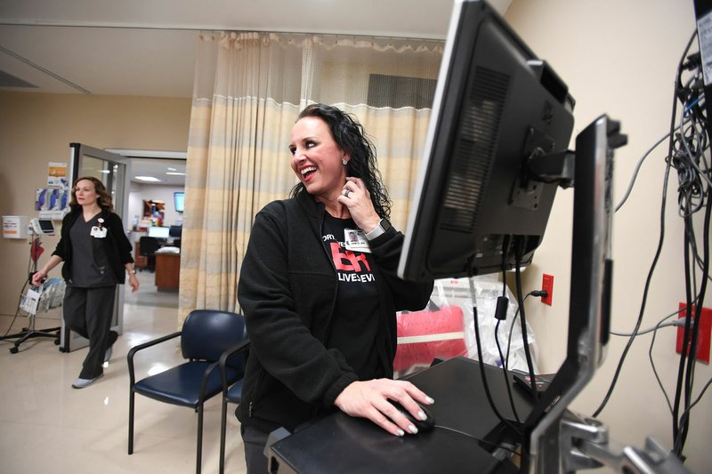 NWA Democrat-Gazette/J.T. WAMPLER Jamie Perry, a registered nurse, logs onto a computer in the emergency room Feb. 26 at Northwest Medical Center's Springdale campus. Reservations to the emergency room can be viewed on any terminal.