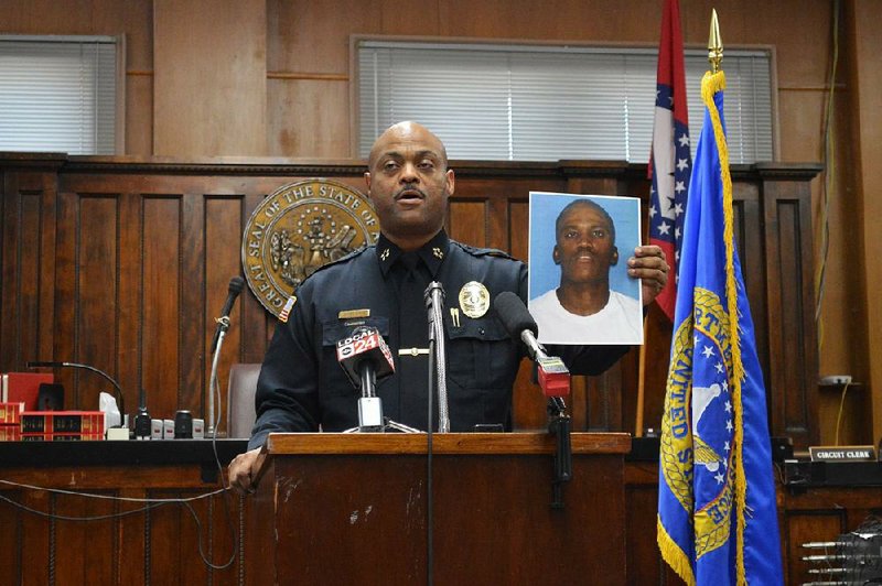 Helena-West Helena Police Chief James Patrick Smith shows a picture of a suspect at a news conference Tuesday at which local and federal officials announced the arrests of 44 people on charges of violent crimes and gang-related activity. “We’re trying to bring back law and order to our city and county,” Smith said. “Today was a good day.” 