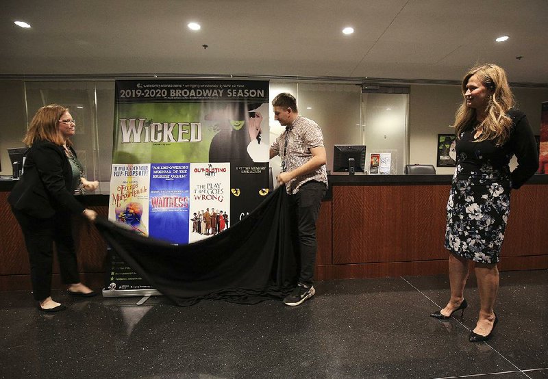 Allison Hiblong (left) and Micheal Richter unveil a poster Tuesday during a news conference for Celebrity Attractions’ 2019-20 season for Little Rock’s Robinson Center Music Hall, as marketing director Deana McCormack talks about the productions. 