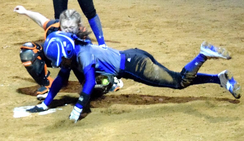 Westside Eagle Observer/MIKE ECKELS Lady Lions catcher Emily Ellis tags a Lady Mounties runner at home plate during the Gravette-Rogers softball contest in Gravette March 1. Ellis' effort came after the runner tagged the plate to score the run.