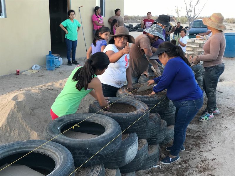 Families work on construction of a home made from tires, clay and red dirt in San Felipe, Mexico. The families are participating in a program offered by Casa Digna, a nonprofit founded by Melody Ashley, of Little Rock. 