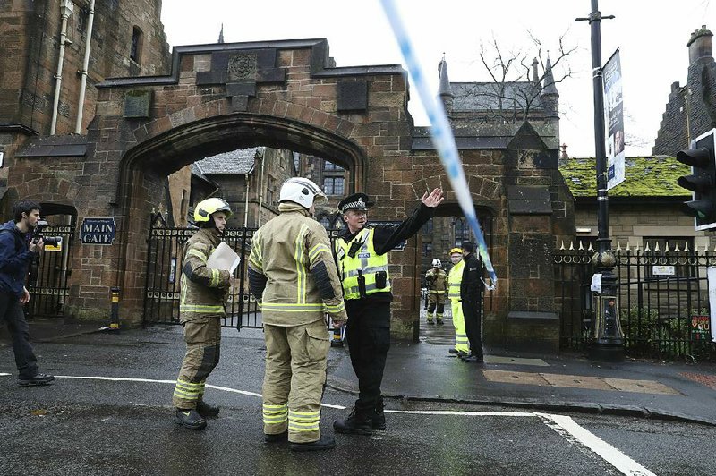 Firefighters and police officers confer Wednesday at the University of Glasgow after a suspicious package was found, prompting the evacuation of several buildings. 