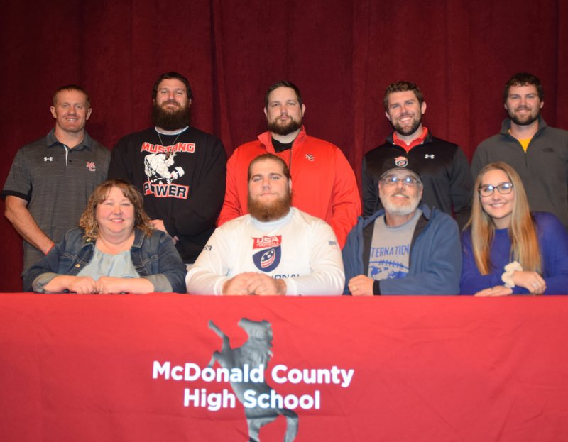 RICK PECK/SPECIAL TO MCDONALD COUNTY PRESS Elliott Wolfe recently signed a letter of intent to play football at Concordia University in St. Paul, Minn. Front row, left to right: Nancy Wolfe (mom), Elliott Wolfe, Dennis Wolfe (dad) and Erin Wolfe (sister). Back row: MCHS coaches Sean McCullough, Craig Collins, Chris Kane, Kellen Hoover and Kanon Hoover. RICK PECK/SPECIAL TO MCDONALD COUNTY PRESS Elliott Wolfe recently signed a letter of intent to play football at Concordia University in St. Paul, Minn. Front row, left to right: Nancy Wolfe (mom), Elliott Wolfe, Dennis Wolfe (dad) and Erin Wolfe (sister). Back row: MCHS coaches Sean McCullough, Craig Collins, Chris Kane, Kellen Hoover and Kanon Hoover.