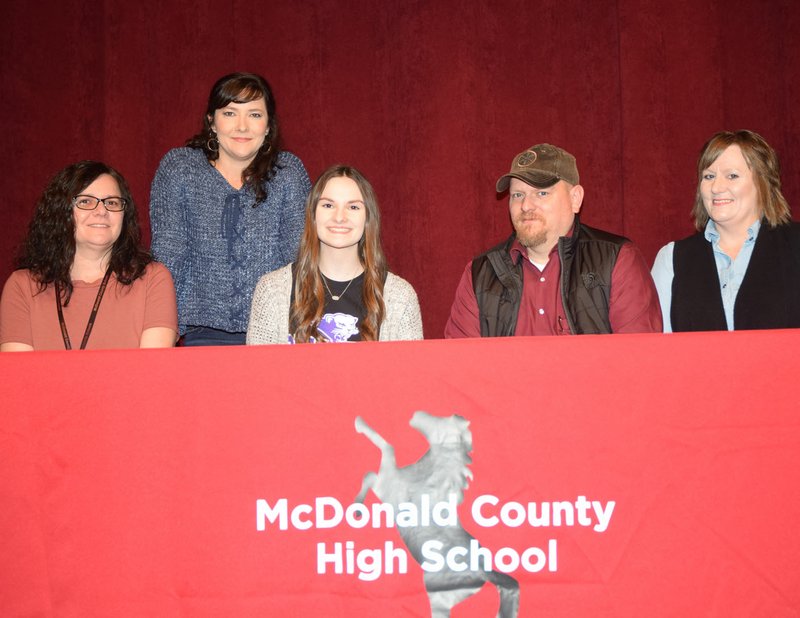 RICK PECK/SPECIAL TO MCDONALD COUNTY PRESS Caitlyn Stouder, a cheerleader at McDonald County High School, recently signed a letter of intent to join next year's cheer squad at Southwest Baptist University in Bolivar. From left to right: Lori Ledford (mom), TC Banta (MCHS coach), Caitlyn Stouder, and Eugene and Tina Stouder (parents).