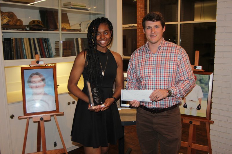 Magnolia senior Kayleigh Sneed holds the 2019 Wes Weiser Youth of the Year Award, while local Boys & Girls Club Board president Brad Smith prepares to present her with the $2,500 Wes Weiser Scholarship. She received the honor Tuesday night.