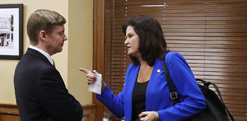 Republican Reps. Jimmy Gazaway of Paragould and Laurie Rushing of Hot Springs talk Wednesday at the state Capitol after he presented House Bill 1410 to the House Insurance and Commerce Committee. Rushing, who is a committee member, sponsored a bill in 2017 that was similar to HB1410. 