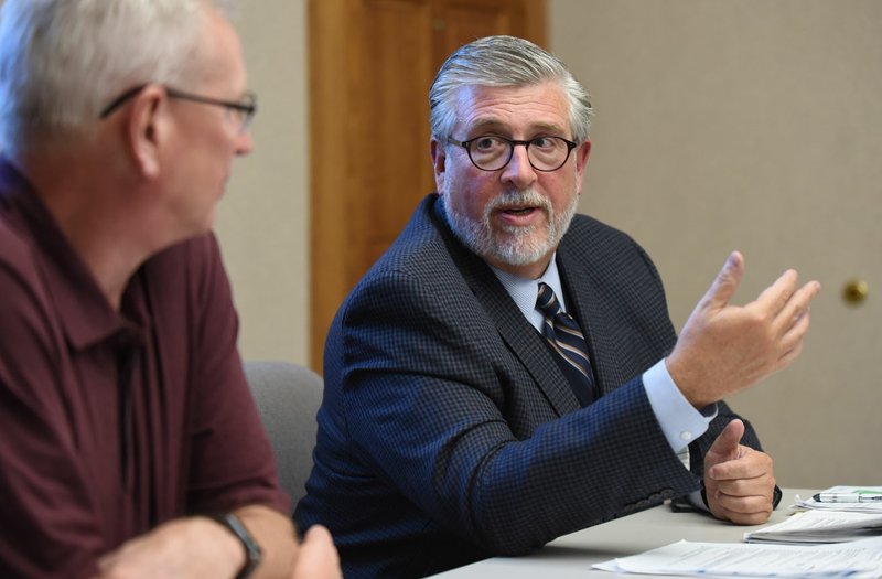 NWA Democrat-Gazette/DAVID GOTTSCHALK Perry Webb (left), president and chief executive officer of the Springdale Chamber of Commerce, listens Thursday to Ted Abernathy, managing partner of Economic Leadership, a consulting firm, discuss the recent study Addressing the Skills Gap: Pipeline Transformation at the chamber office in Springdale. The report identifies skilled careers that will be in high demand in the next decade and ways to develop the workforce.