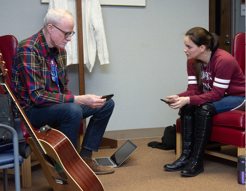 Songwriter and Operation Song founder Bob Regan and veteran Lesa Dickson of Mayflower listen to different types of music, trying to find a style for a song that chronicles Dickson’s story. (Arkansas Democrat-Gazette/CARY JENKINS)
