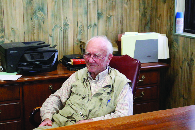 Bob Brown sits in his office, a sparsely furnished room in what used to be a hotel. Outside his office is an arrow pointing in that reads ‘Bob’s Tiki Bar.’