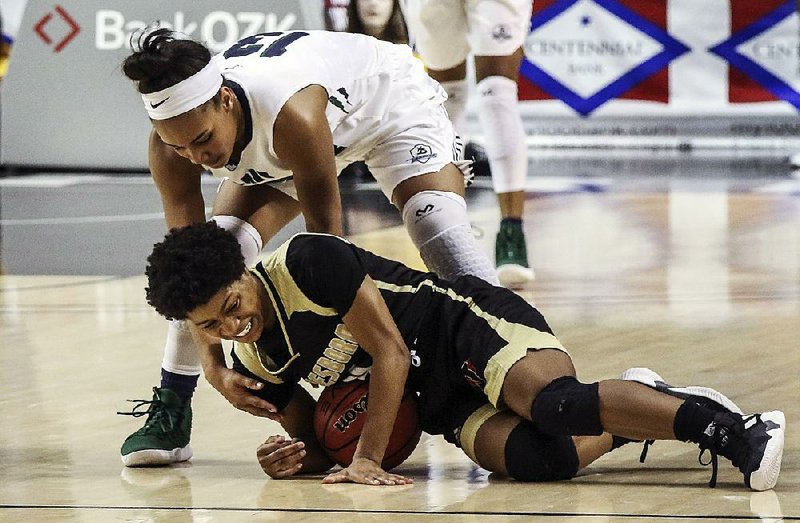 Little Rock Christian’s Reagan Bradley (top) battles Jonesboro’s Kayla Mitchell in the Lady Warriors’ 63-35 victory Friday night in the Class 5A girls state basketball championship at Bank OZK Arena in Hot Springs. For more photos go to www.arkansasonline.com/308girls5a/
