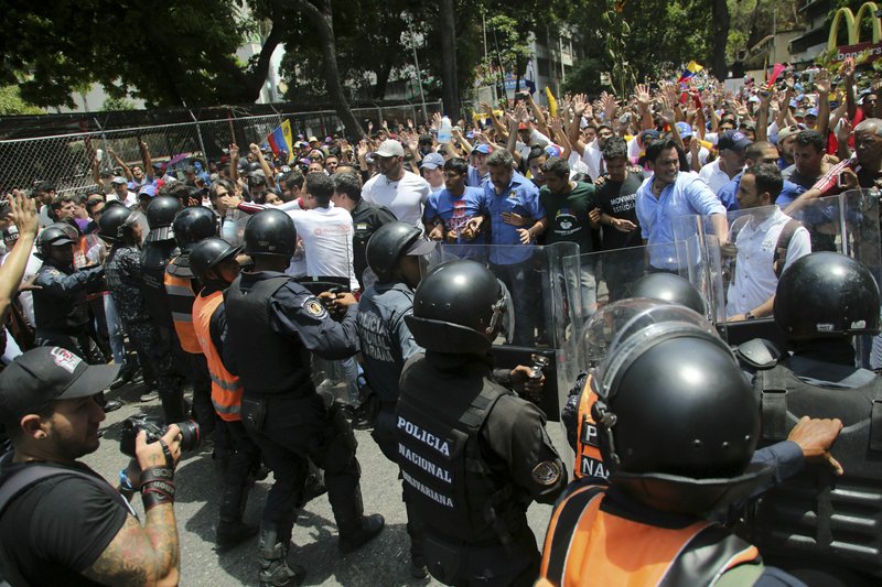 Demonstrators on Saturday confront a cordon of Venezuelan National police, who temporarily blocked members of the opposition from reaching a rally in Caracas, Venezuela against the government of President Nicolas Maduro. (AP Photo/Fernando Llano)