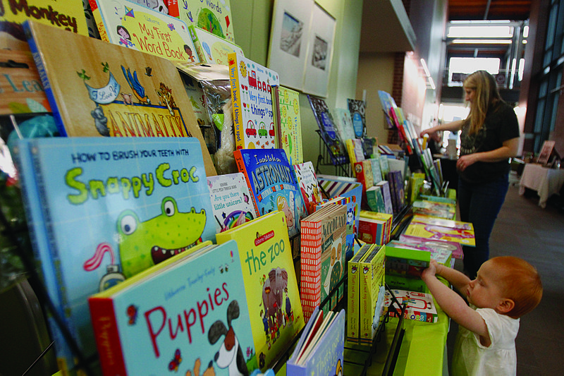Festival: Above, two-year-old Virginia Louise Young searches for books while attending the South Arkansas Literary Festival at the El Dorado Conference Center on Saturday.  Terrance Armstard/News-Times