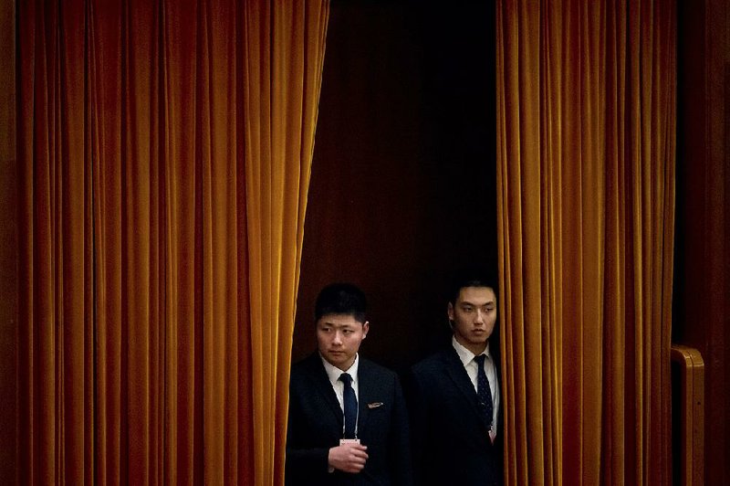 Security officers stand watch Saturday before a meeting of an advisory body for the National People’s Congress at the Great Hall of the People in Beijing. At a news conference in conjunction with the legislative session, trade negotiator Wang Shouwen suggested a way to solve the trade dispute with the U.S. 