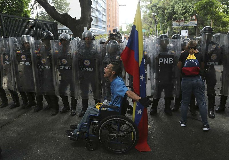 A protester vents his frustration Saturday in Caracas, Venezuela, as police officers temporarily block opposition supporters from getting to a rally against President Nicolas Maduro’s government. 