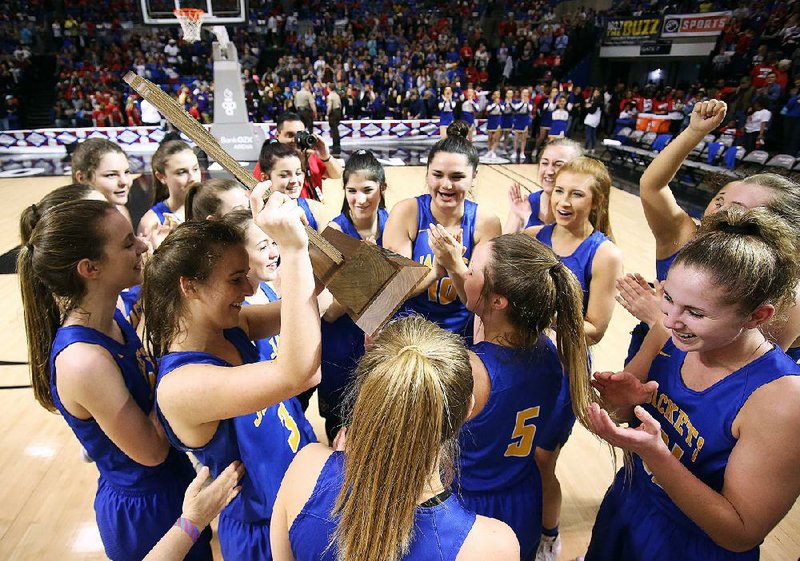 Mountain View players celebrate with the state championship trophy Saturday after defeating Atkins 59-48 for the Class 3A girls championship at Bank OZK Arena in Hot Springs. For more photos, visit arkansasonline.com/310girls3a/. 