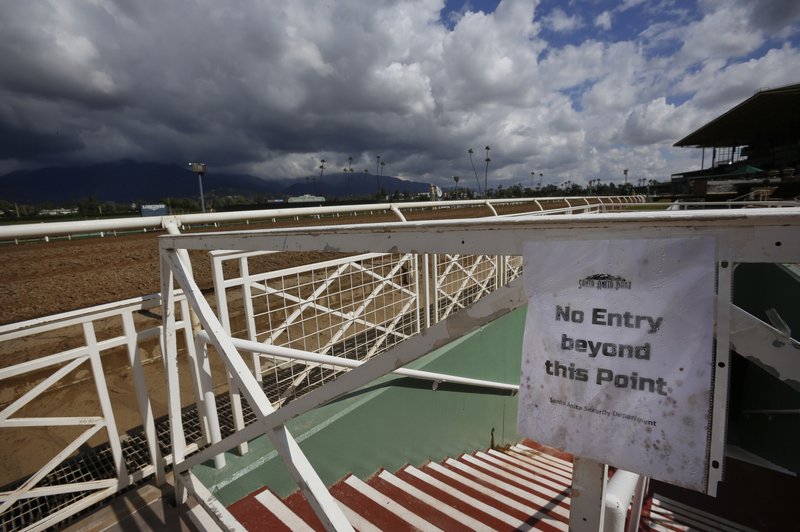 Heavy clouds are seen over the San Gabriel Mountains at Santa Anita Park in Arcadia, Calif., Thursday, March 7, 2019. Extensive testing of the dirt track is under way at eerily quiet Santa Anita, where the deaths of 21 thoroughbreds in two months has forced the indefinite cancellation of horse racing and thrown the workaday world of trainers, jockeys and horses into disarray. (AP Photo/Damian Dovarganes)