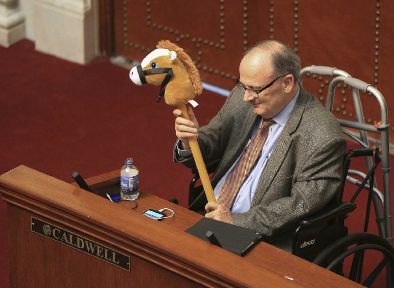 Sen. Ronald Caldwell, R-Wynne, holds up a toy horse Monday in the Senate as Sen. Gary Stubblefield, R-Branch, presents a SB405 on equine testing. 