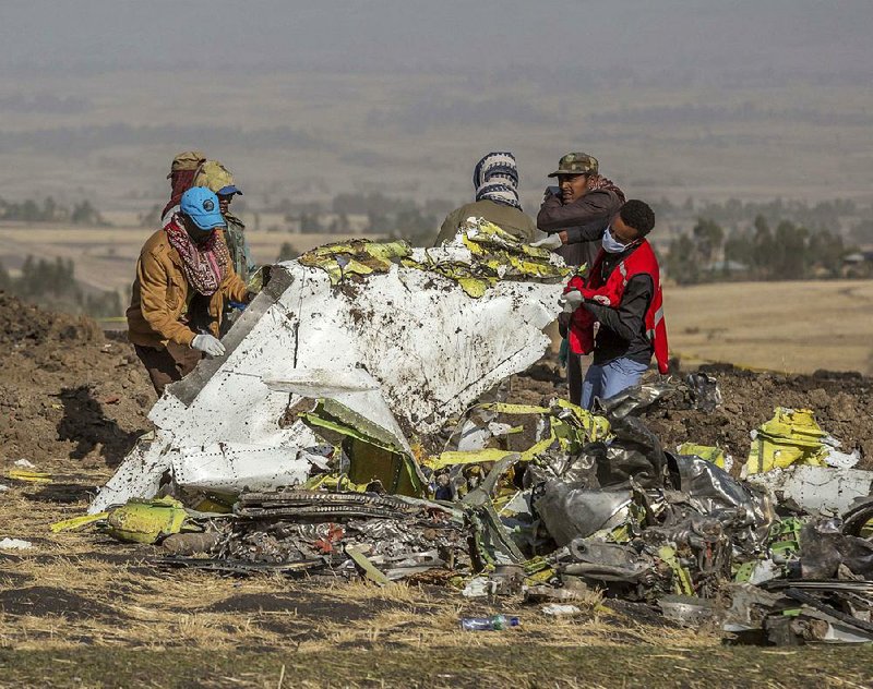 Rescuers work Monday at the scene where an Ethiopian Airlines flight crashed south of Addis Ababa, Ethiopia. A spokesman says Ethiopian Airlines has grounded all its Boeing 737 Max 8 aircraft as a safety precaution. 