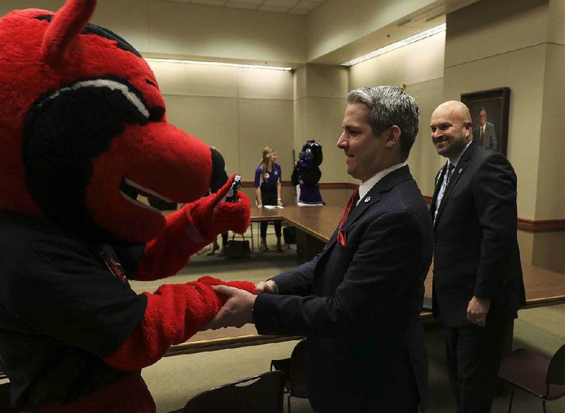 Christopher Dickey (center) and Arkansas Drug Director Kirk Lane (right) get a sign of approval from the Arkansas State University mascot Monday after speaking at a press conference to kick off Save AR Students week to raise awareness about substance abuse.