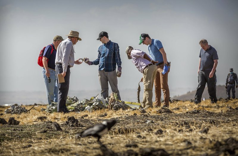 Foreign investigators examine wreckage at the scene where the Ethiopian Airlines Boeing 737 Max 8 crashed shortly after takeoff on Sunday killing all 157 on board, near Bishoftu, or Debre Zeit, south of Addis Ababa, in Ethiopia Tuesday, March 12, 2019. Ethiopian Airlines had issued no new updates on the crash as of late afternoon Tuesday as families around the world waited for answers, while a global team of investigators began picking through the rural crash site. (AP Photo/Mulugeta Ayene)