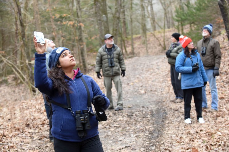 NWA Democrat-Gazette/FLIP PUTTHOFF Pooja Panwar uses bird calls on her phone to attract birds during the Great backyard Bird Count.