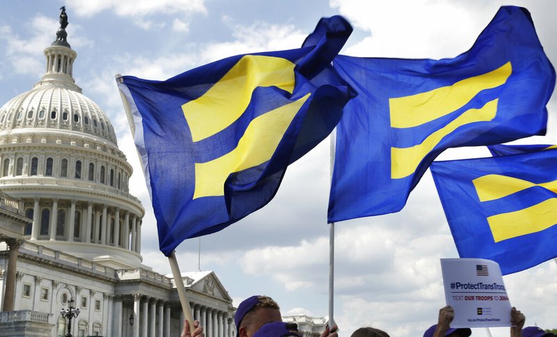 In this Wednesday, July 26, 2017 file photo, people with the Human Rights Campaign hold up "equality flags" during an event organized by Rep. Joe Kennedy, D-Mass., in support of transgender members of the military on Capitol Hill in Washington, after President Donald Trump said he wants transgender people barred from serving in the U.S. military. Congress will soon consider a comprehensive LGBT nondiscrimination bill, but it could well be doomed by lack of Republican support. (AP Photo/Jacquelyn Martin)