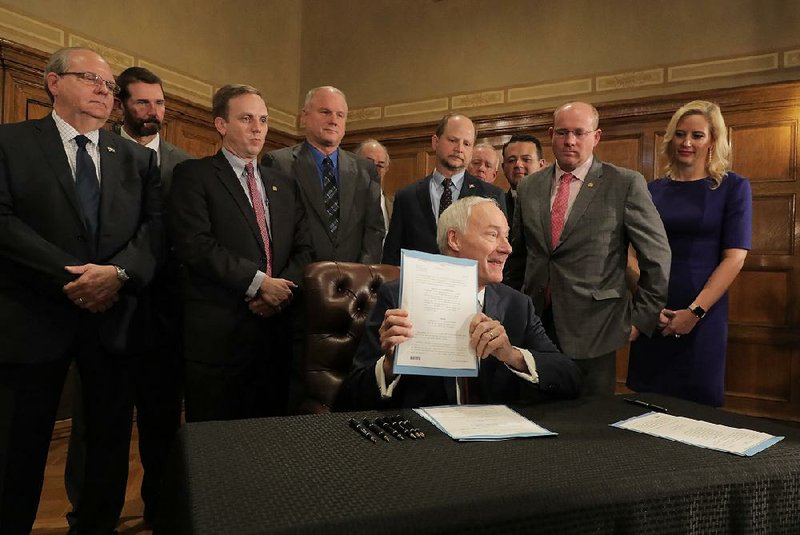 Gov. Asa Hutchinson holds a news conference Tuesday to sign legislation that raises fuel taxes and fees and reallocates other resources to increase highway funding. The other half of the funding plan, a sales-tax extension, will be referred to voters in the 2020 general election. 