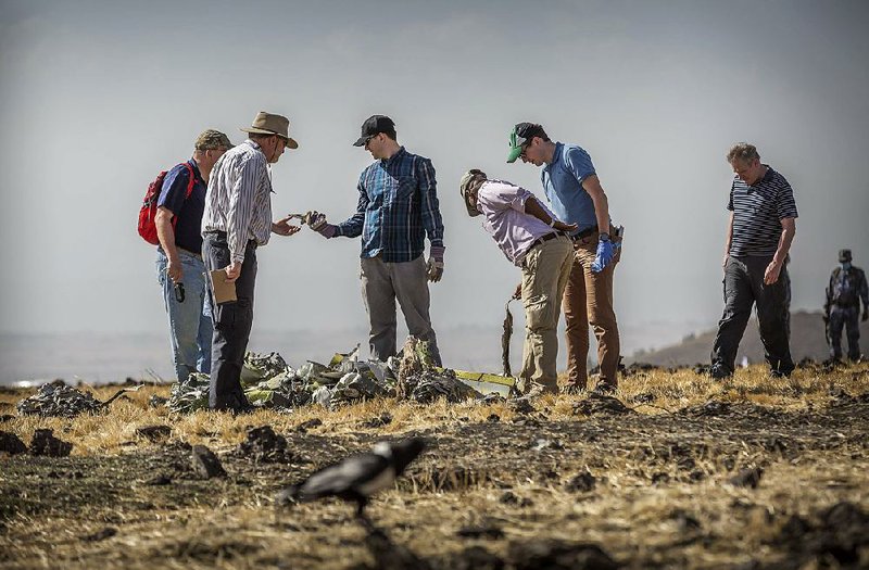Investigators examine wreckage Tuesday at the scene of the Boeing 737 Max 8 crash south of Addis Ababa, Ethiopia. 