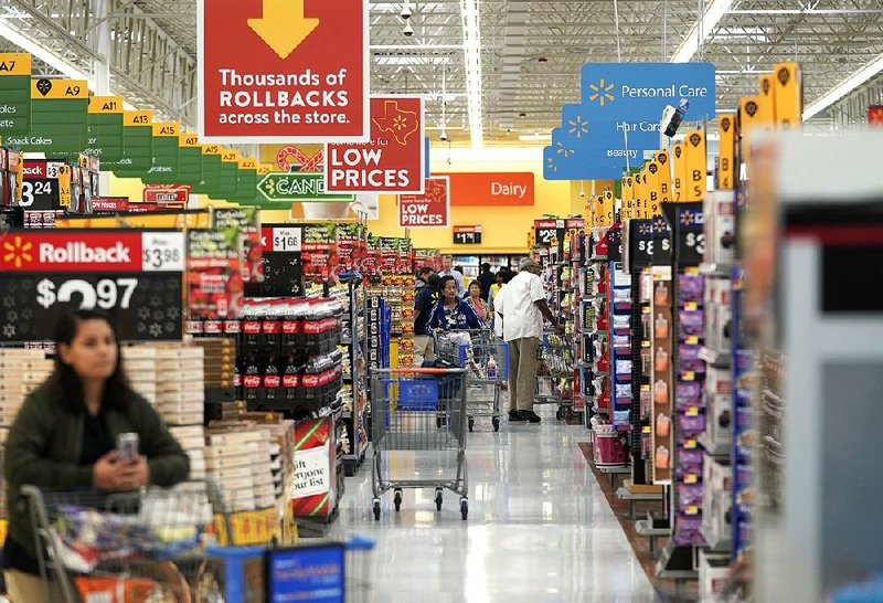 People shop in a Walmart Supercenter in Houston last fall. Even with modest inflation, many Americans are facing higher prices for basic necessities. 