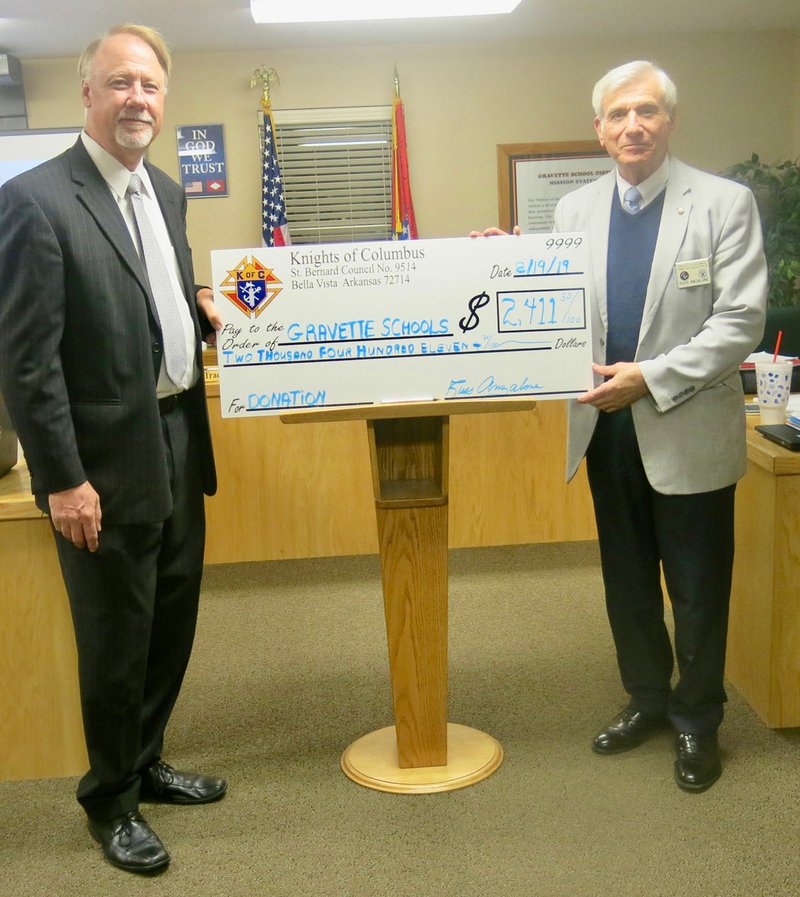 Richard Page (left), superintendent of Gravette Schools, accepts a check from Russ Anzalone in the amount of $2,411. This donation, from the St. Bernard Council of Knights of Columbus in Bella Vista, is from proceeds of the organization's annual Tootsie Roll sales campaign and will be used for Gravette Schools special education department.
