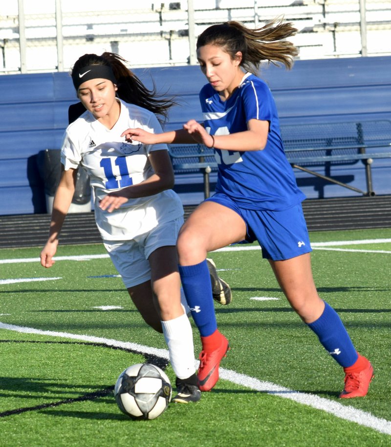 Westside Eagle Observer/MIKE ECKELS Kaylee Morales (Decatur 11) tries to steal the ball away from Estela Stopani (Rogers 12) during the first half of the March 6 Rogers JV-Decatur non-conference soccer match at Mountaineer Stadium in Rogers. The Lady Mounties defeated the Lady Bulldogs, 8-0, in Decatur first girls' match of the 2019 season.