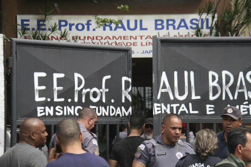 Police officers guard the entrance of the Raul Brasil State School in Suzano, Brazil, Wednesday, March 13, 2019. The state government of Sao Paulo said two teenagers, armed with guns and wearing hoods, entered the school and began shooting at students. They then killed themselves, according to the statement. (Mauricio Sumiya/Futura Press via AP)

