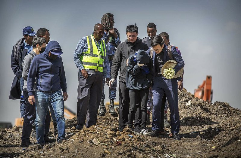 Chinese relatives of victims of the Boeing 737 Max 8 crash in Ethiopia grieve Wednesday during a visit to the crash site south of Addis Ababa, Ethiopia’s capital. 