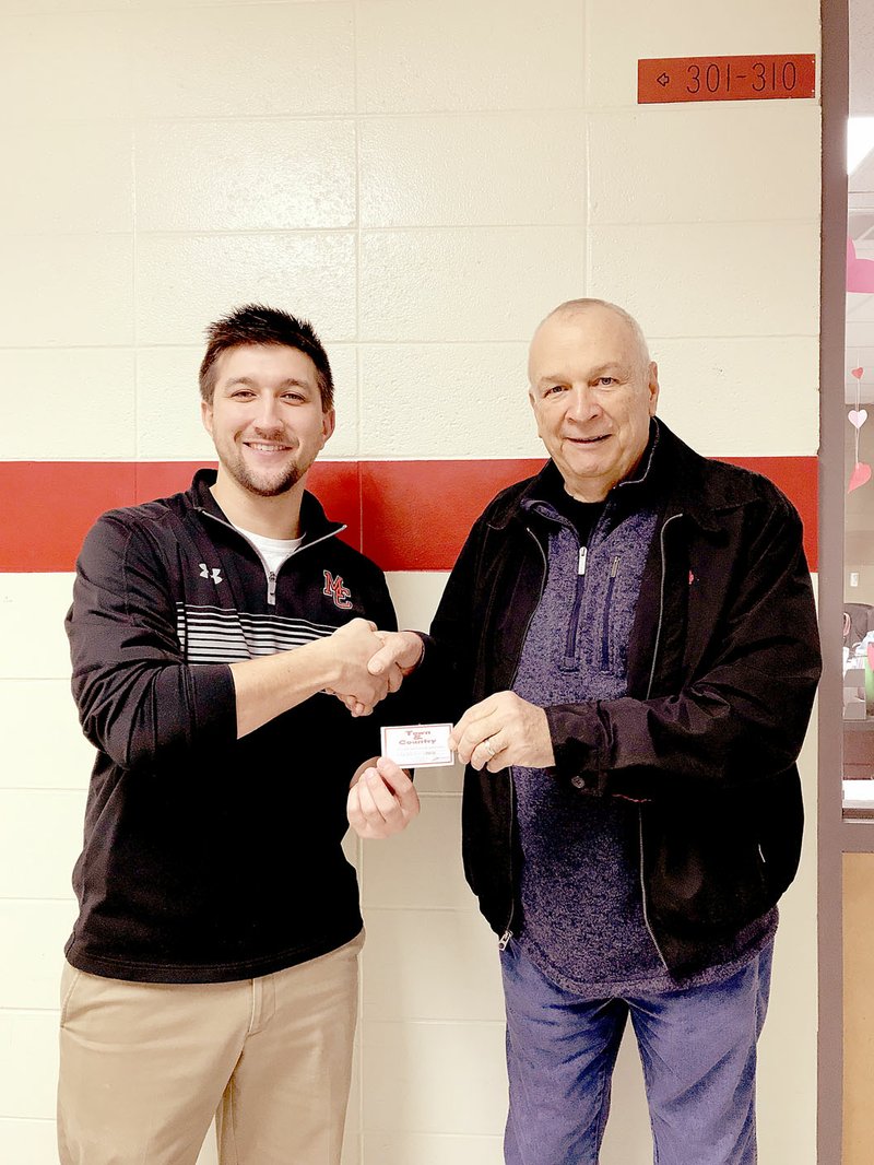 COURTESY PHOTO Michael Shaddox, counselor at McDonald County High School, accepts a $500 gift certificate to Town and Country from John Hobbs of Farm Bureau for the school's food pantry.