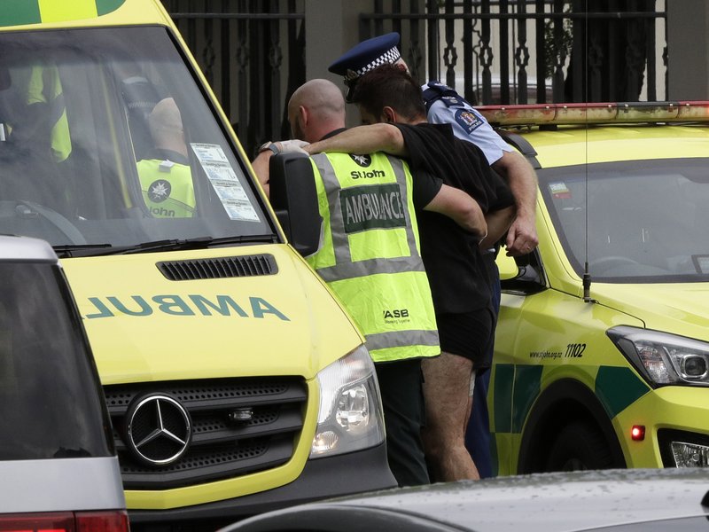 Police and ambulance staff help a wounded man from outside a mosque in central Christchurch, New Zealand, Friday, March 15, 2019. A witness says many people have been killed in a mass shooting at a mosque in the New Zealand city of Christchurch. (AP Photo/Mark Baker)

